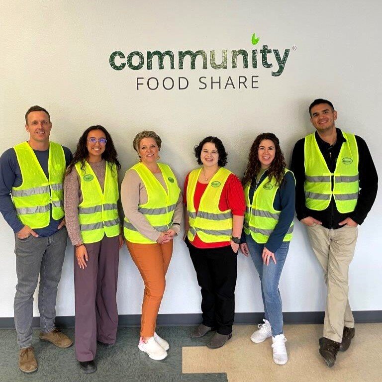 Flatirons Bank employees in volunteer vests in front of the Community Food Share sign